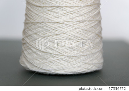 White bobbins of wool yarn for hand and machine knitting close-up White bobbins of wool yarn for hand and machine knitting close-up 57556752