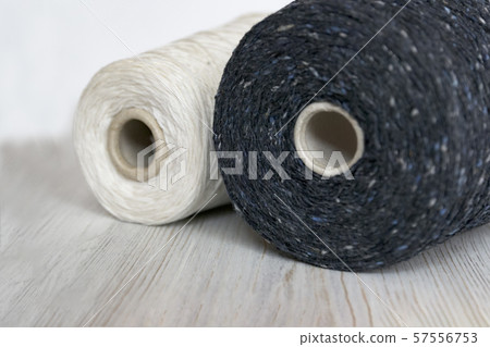Monochrome color bobbins of wool yarn for hand and machine knitting on a light coloured background Monochrome color bobbins of wool yarn for hand and machine knitting on a light coloured background 57556753