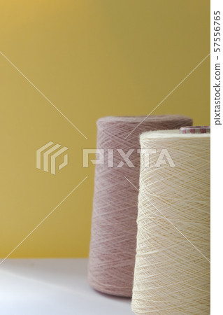 Pastel color bobbins of wool yarn for hand and machine knitting on a yellow background Pastel color bobbins of wool yarn for hand and machine knitting on a yellow background 57556765