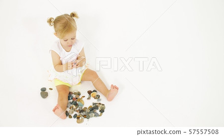 Blonde baby girl plays with sea pebble. Vacation related clip Blonde baby girl plays with sea pebble. Vacation related clip 57557508