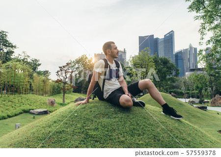 Young man sitting on the grass Male portrait outdoors 57559378