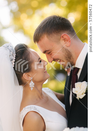 Beautiful bride with her husband in the park. Background of yellow tree. Happy couple. Clouse up Beautiful bride with her husband in the park. Background of yellow tree. Happy couple. Clouse up 57560472