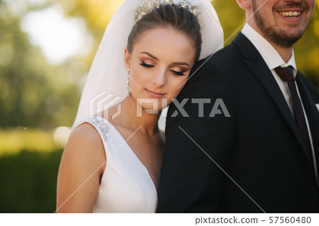 Beautiful bride with her husband in the park. Background of yellow tree. Happy couple Beautiful bride with her husband in the park. Background of yellow tree. Happy couple 57560480