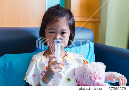 Asian child holds a mask vapor inhaler for treatment of asthma. Asian child holds a mask vapor inhaler for treatment of asthma. 57560979