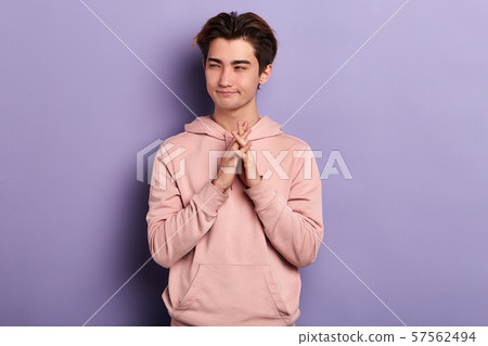 cunning man makes grimace, keeps palms together 57562494