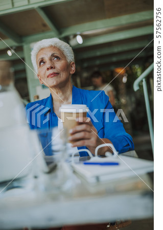 Thoughtful woman with coffee looking up stock photo Thoughtful woman with coffee looking up stock photo 57562756