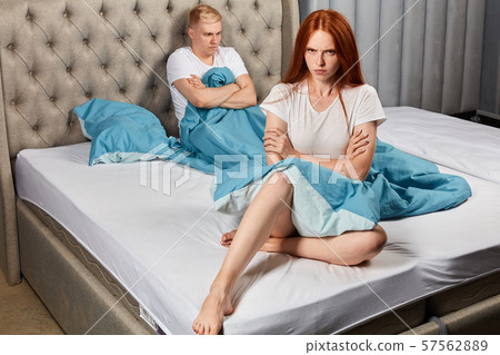 angry unhappy couple isn't talking after argument in bed at home in bedroom 57562889