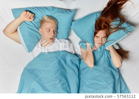 angry ginger woman closing her ears with pillow angry ginger woman closing her ears with pillow 57563112