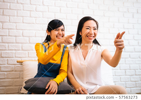 Excited Asian females watching TV 57563273