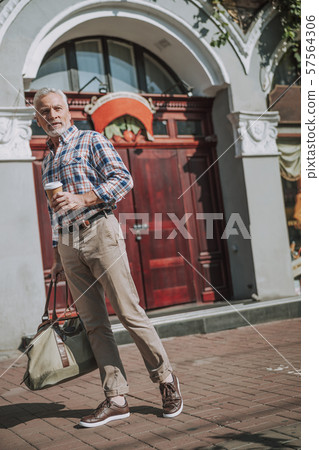 Confident mature traveler with coffee to go stock photo Confident mature traveler with coffee to go stock photo 57564306