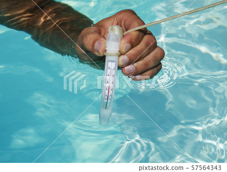 Closeup of swimming pool thermometer in man hand ,pool water is warm. Closeup of swimming pool thermometer in man hand ,pool water is warm. 57564343