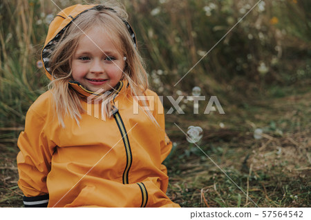 Happy pretty girl is sitting on grass 57564542