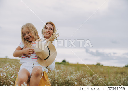 Pretty smiling mother is hugging her daughter Pretty smiling mother is hugging her daughter 57565059
