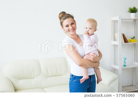 Childhood, family and motherhood concept - Mother holding sweet baby girl Childhood, family and motherhood concept - Mother holding sweet baby girl 57565060