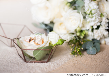 Two wedding rings in beautiful box and bouquet of flowers. Themes of engagement, declaration of love Two wedding rings in beautiful box and bouquet of flowers. Themes of engagement, declaration of love 57565062