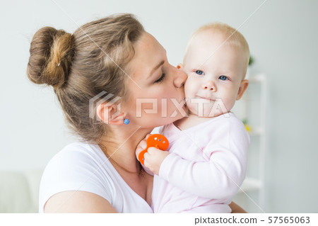 Mother hugs little baby. Happy woman with her daughter close-up Mother hugs little baby. Happy woman with her daughter close-up 57565063