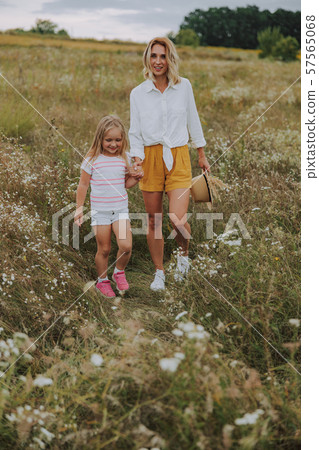 Pretty woman is walking with her daughter Pretty woman is walking with her daughter 57565068
