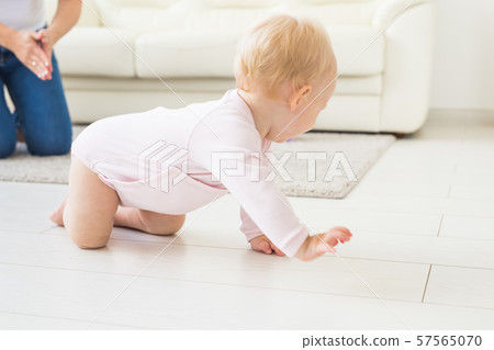 Smiling crawling baby girl at home on floor Smiling crawling baby girl at home on floor 57565070