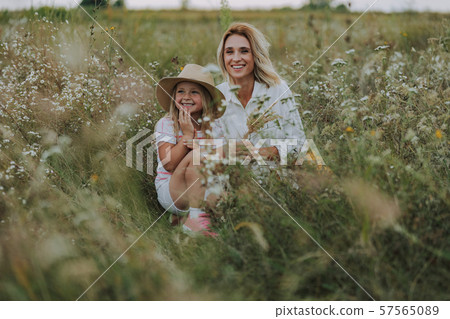 Beautiful mother laughing with her small daughter in field 57565089