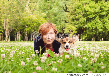 Beautiful senior woman with dog in spring nature Beautiful senior woman with dog in spring nature 57565184