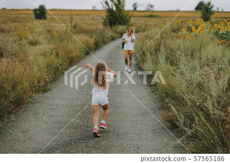 Little Caucasian girl walking on road outdoors Little Caucasian girl walking on road outdoors 57565186