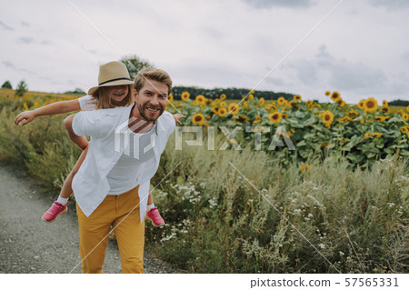 Cheerful daughter spending time with her dad near field 57565331