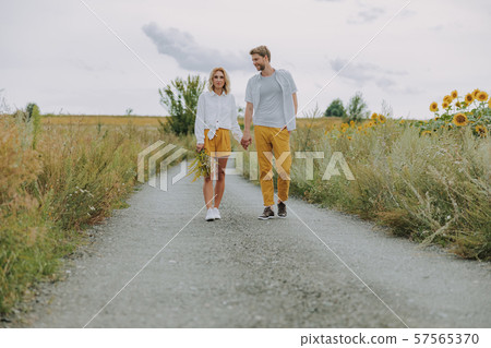 Happy smiling young couple walking together outdoors 57565370