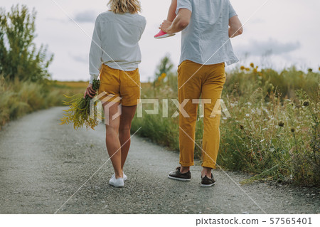 Calm young parents walking on the road outdoors 57565401