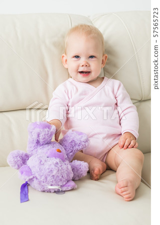 Children, infant and childhood concept - beautiful smiling baby sitting Children, infant and childhood concept - beautiful smiling baby sitting 57565723