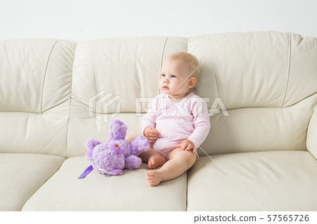 Child, childhood and kids concept - beautiful smiling baby sitting 57565726