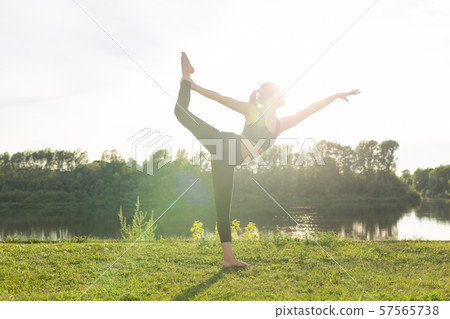 Healthy lifestyle and harmony concept - Young girl doing yoga outdoor 57565738