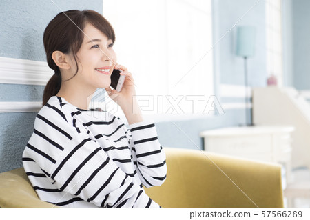 A young woman operating a smartphone 57566289
