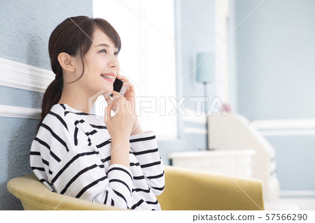 A young woman operating a smartphone 57566290