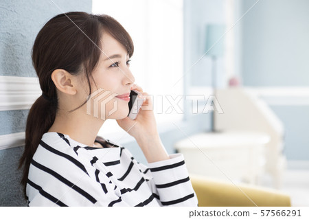 A young woman operating a smartphone 57566291