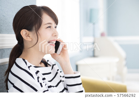 A young woman operating a smartphone 57566292
