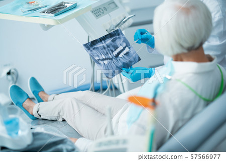 Dentist is showing x-ray of the jaw Dentist is showing x-ray of the jaw 57566977