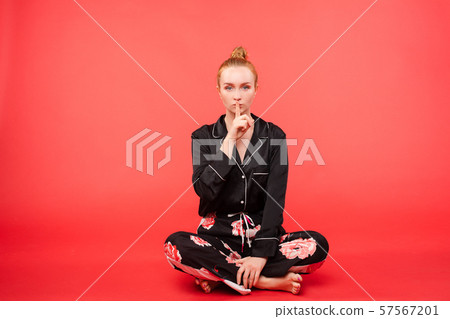 Young girl sitting on floor and meditating with 57567201