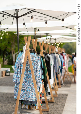 Racks with clothes outdoors. Designer sells Racks with clothes outdoors. Designer sells 57567513