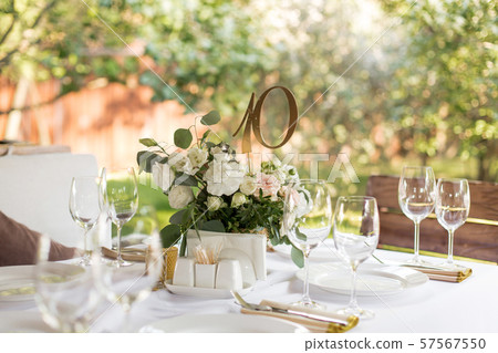 Wedding table setting decorated with fresh flowers Wedding table setting decorated with fresh flowers 57567550
