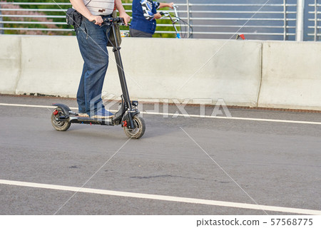 Close up of man driving on electric scooter in city 57568775