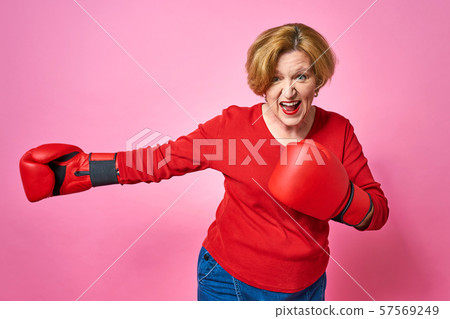 Woman aged in boxing gloves. The concept of the fight against old age. 57569249