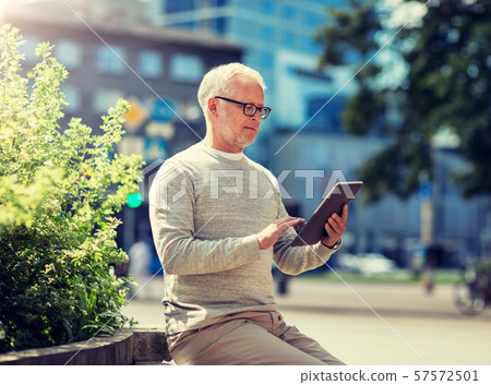 senior man with tablet pc on city street 57572501
