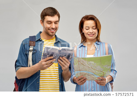 happy couple of tourists with city guide and map 57572571