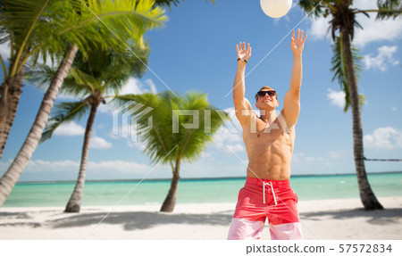 young man with ball playing volleyball on beach young man with ball playing volleyball on beach 57572834