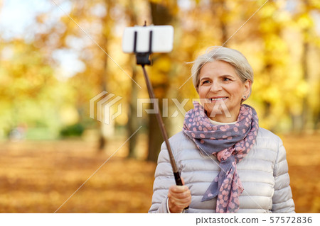senior woman taking selfie at autumn park senior woman taking selfie at autumn park 57572836