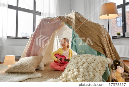 little girl playing guitar in kids tent at home little girl playing guitar in kids tent at home 57572837