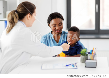 doctor examining african baby's mouth at clinic 57573164