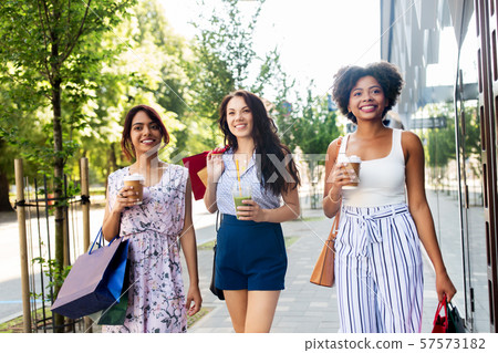 women with shopping bags and drinks in city 57573182