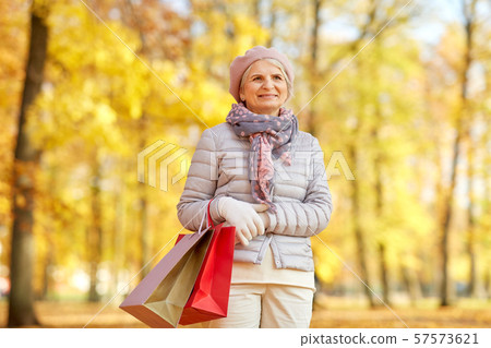 senior woman with shopping bags at autumn park senior woman with shopping bags at autumn park 57573621