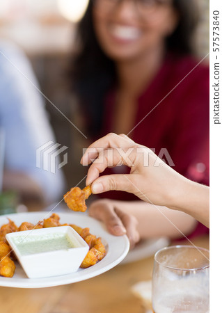 hand with snack and dip sauce at restaurant 57573840